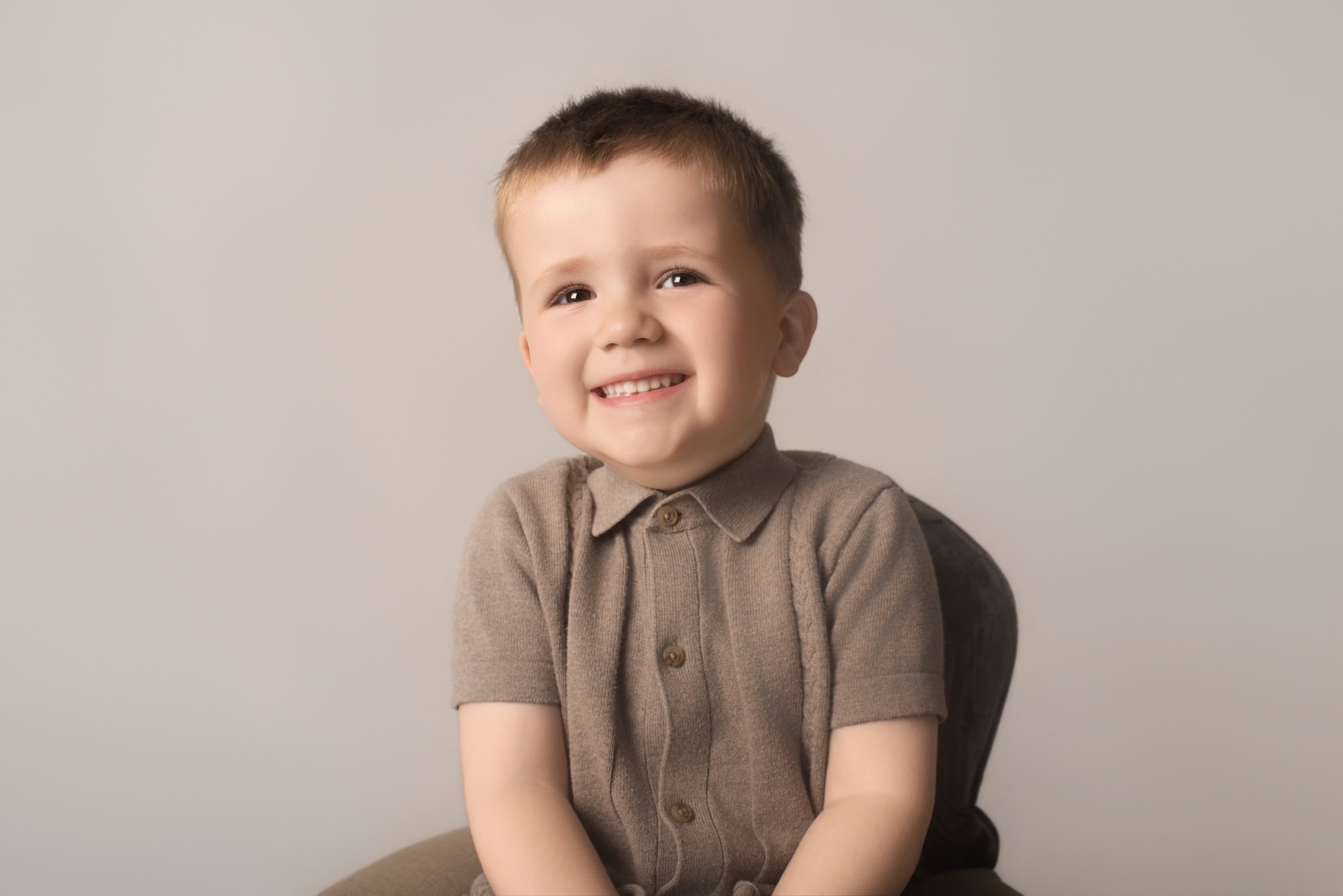 Toddler boy smiling during a sitter session at Gemma Yeomans Photography, Derbyshire